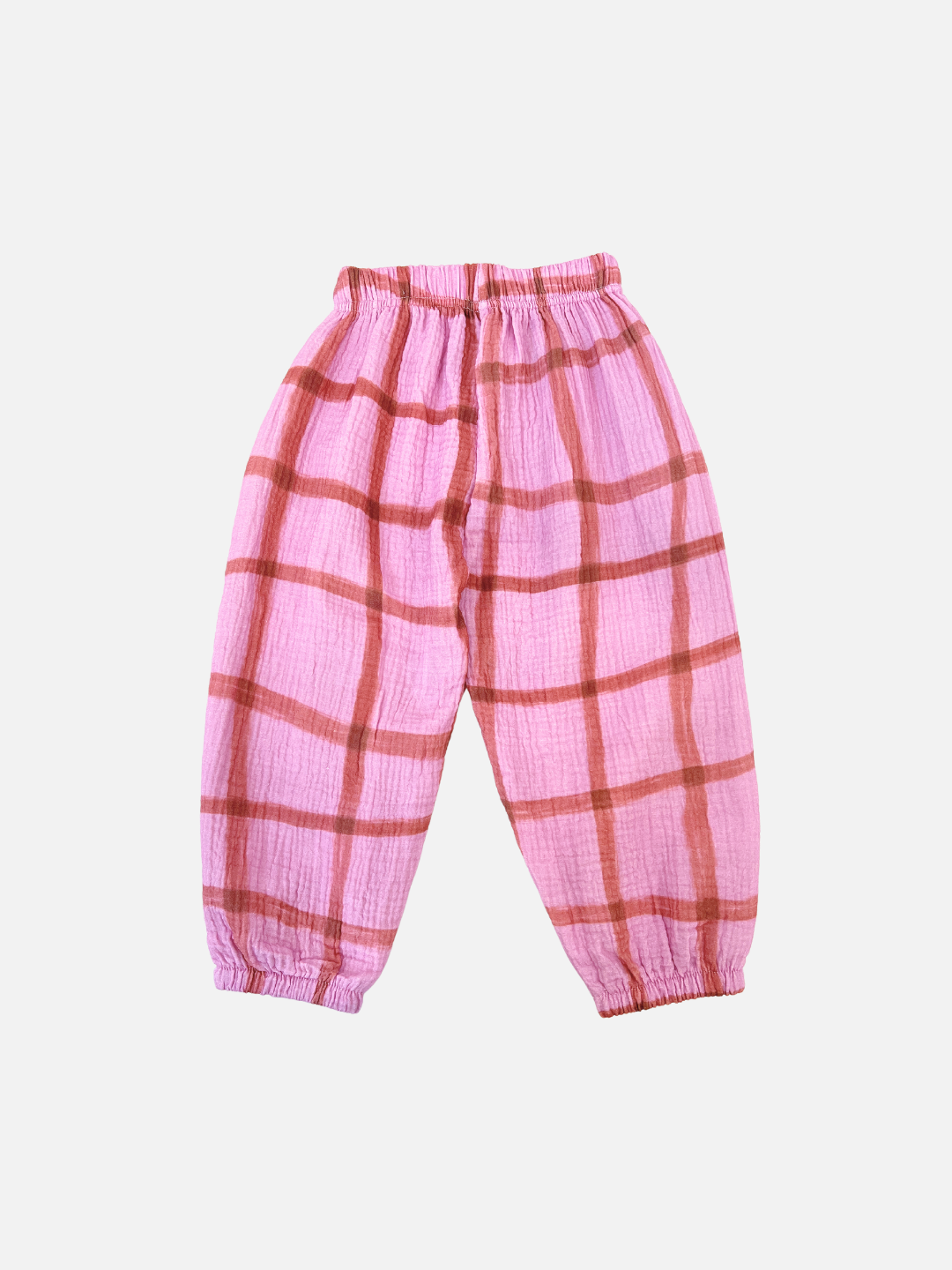 Pink/Terracotta | PAINTBRUSH CHECK MUSLIN PANTS for toddlers in Pink/Terracotta feature an elastic waistband and cuffs, showcasing a hand-drawn grid check pattern on a plain white background.