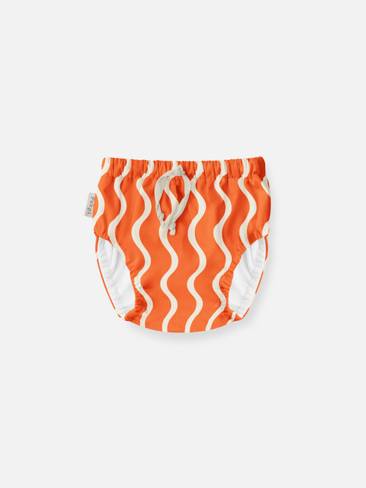 Image of Spaghetti | The front view of the swim diaper with an elastic waist with a tie and elastic leg holes. The diaper is a bright orange with wavy and vertical cream colored lines.