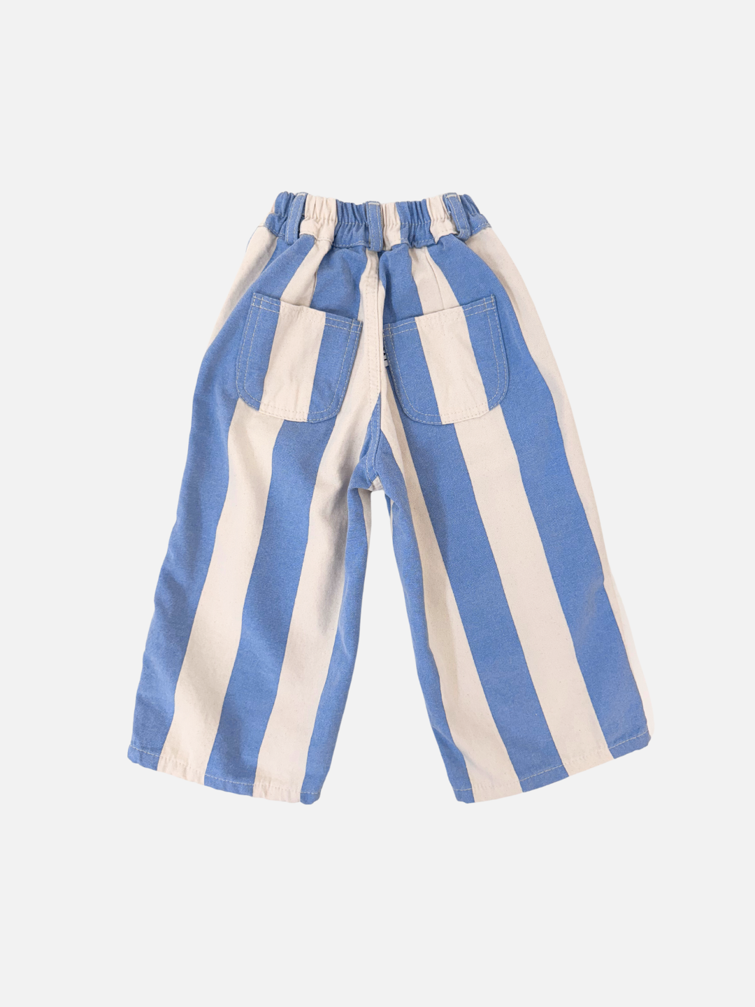 The CABANA STRIPE PANTS, from a Korean children's brand, are blue and white vertically striped cotton canvas with a high waist, elastic waistband, and two back pockets, displayed on a white background.