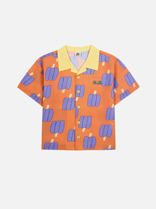 Image of Orange kids shirt with purple bell pepper pattern and a yellow collar on a white background