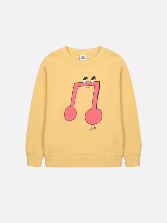 Image of The MELODY SWEATSHIRT is a yellow crewneck with a large pink musical note graphic, complete with eyes and a smile—shop this cheerful style