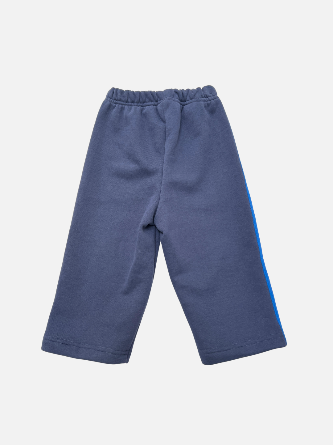 Navy | The SUNDAY TRACKPANTS are navy blue cotton fleece pants featuring an elastic waistband and a blue side stripe, shown laid flat on a white background.