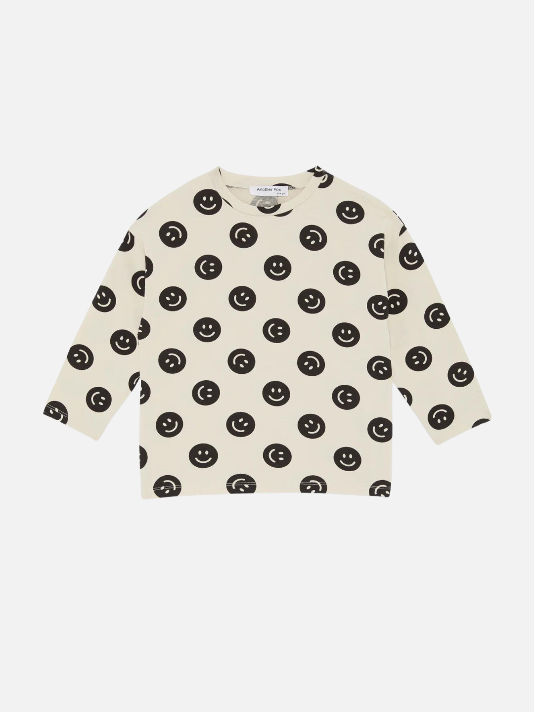 A front view of the cream colored, long sleeve shirt with a black smiley face pattern.