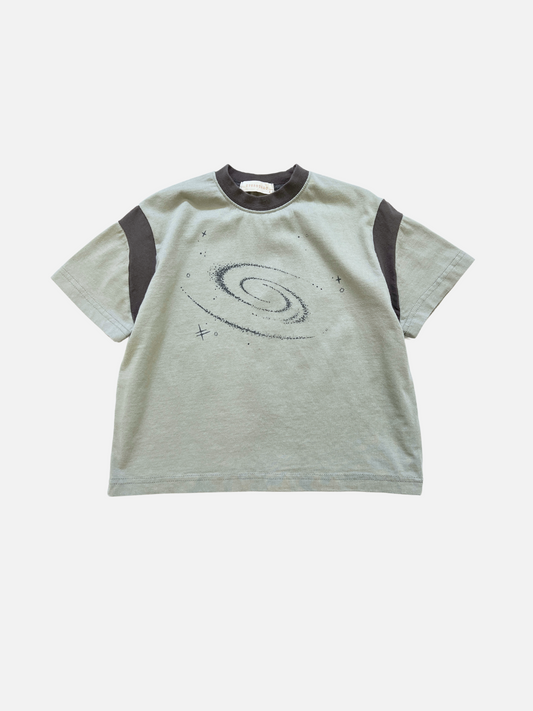 Image of The GALAXY TEE is a light gray oversized cotton t-shirt by Eyescream, a Korean kids brand, with dark gray shoulder panels and a bold black spiral galaxy graphic on the front.