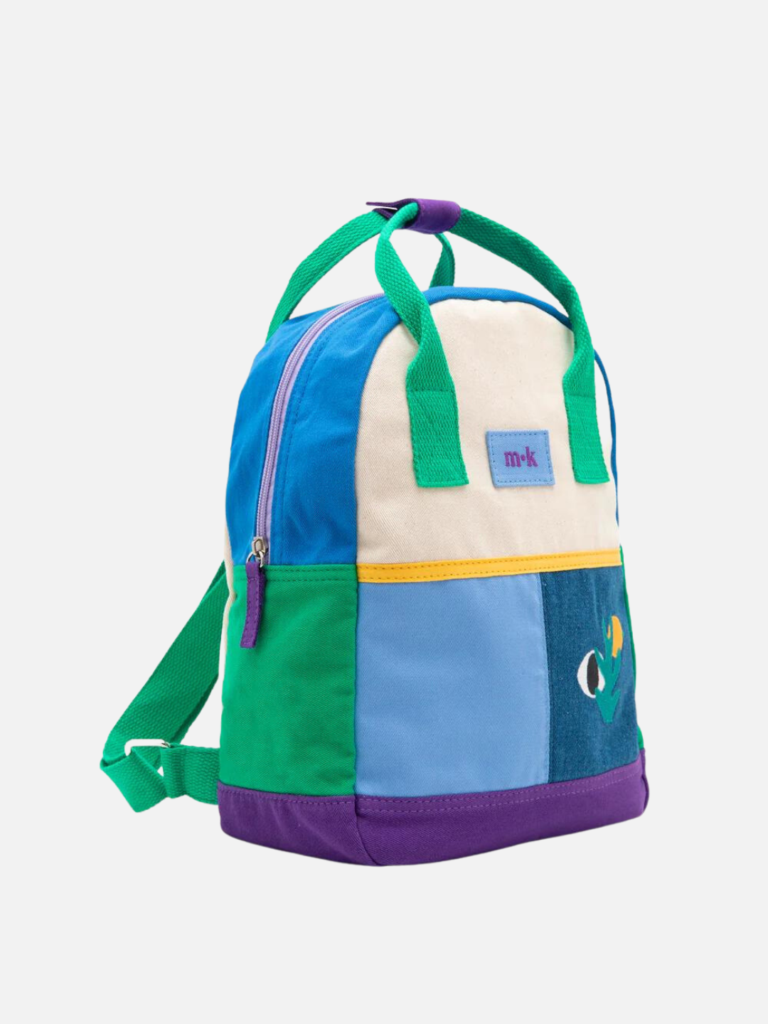 Banana Haven | Side view of a colorblock backpack with green handles, straps and side, purple base, blue top, with two blue patches at the front under a cream top, one with images of an eye, a sun and a plant
