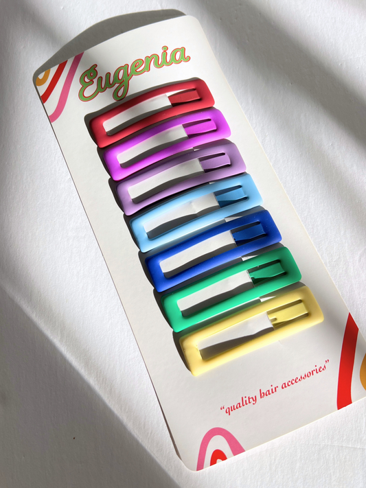 Second image of Seven vibrant jumbo rainbow snap clips are arranged in a vertical line on a white background, exuding a cheerful aura that reflects the playful style of Eugenia Kids.