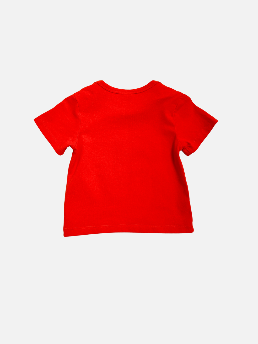 The AIRPLANE BABY TEE, a plain red toddler t-shirt with short sleeves, is shown laid flat with the back side facing up against a white background.