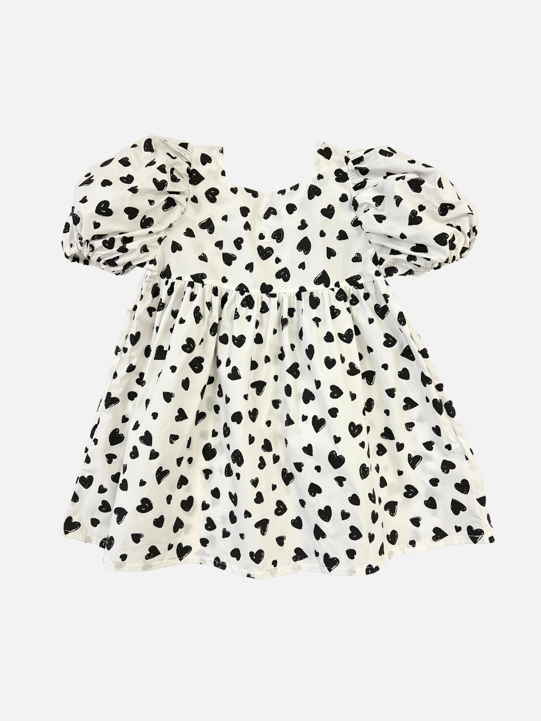 A kids' puff-sleeved dress with a pattern of black hearts on a white background