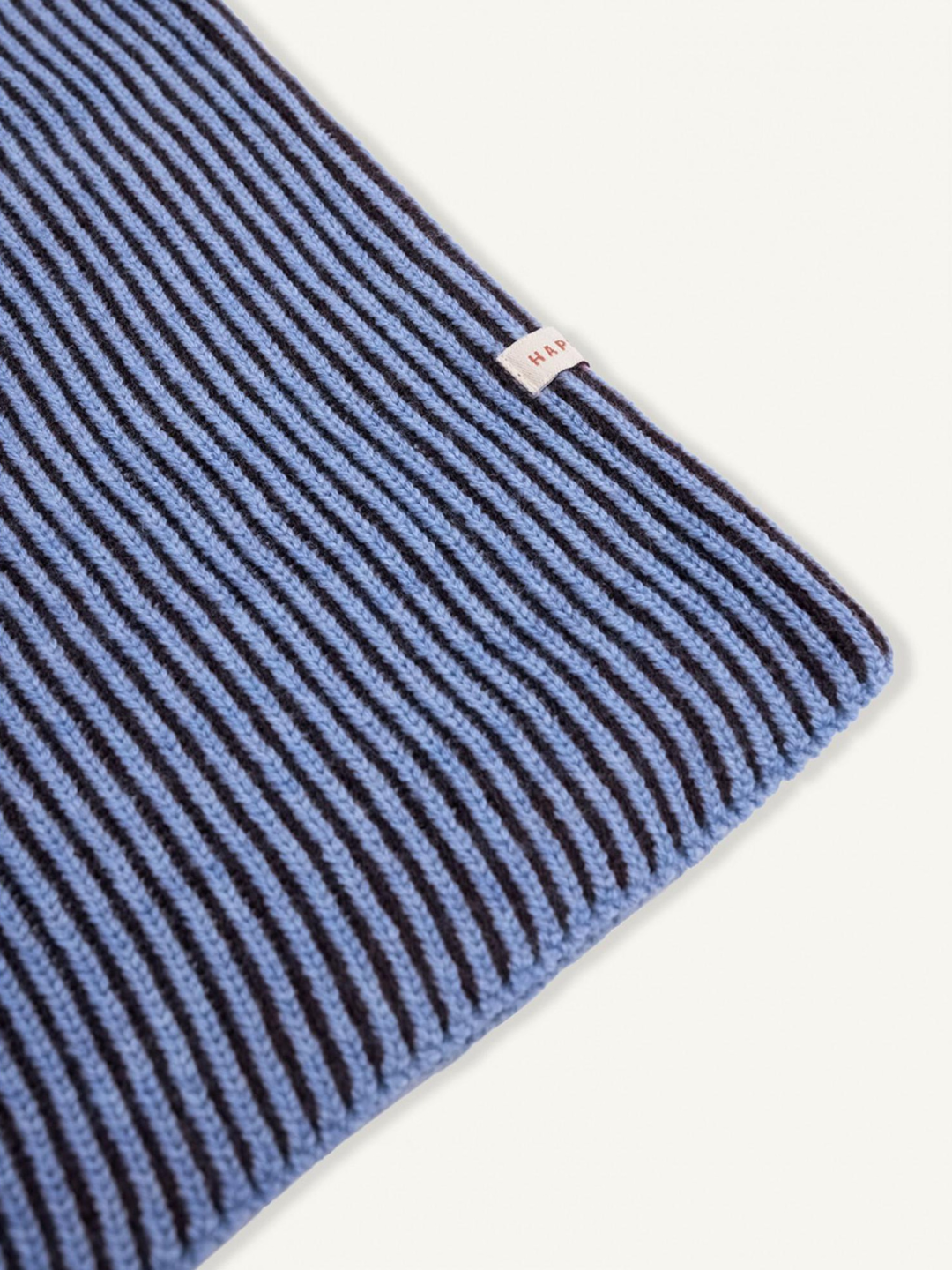 Icy Stripes | Close-up of MERINO BALACLAVA's ribbed knit fabric in blue and black stripes with a small white "HAY" tag, highlighting its cozy texture and thermal comfort.