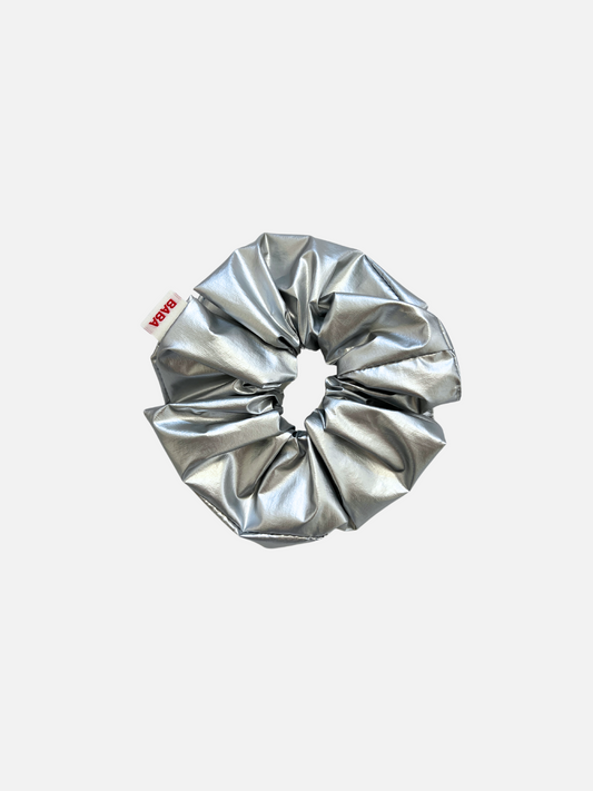 Image of A silver metallic scrunchie with a red "Baba" logo tag on the side.