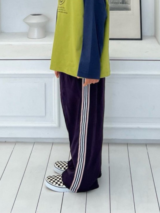 Second image of Purple | MASKING TAPE PANTS in purple, featuring crisp white vertical side stripes, an elastic waistband for comfort, and wide legs. Displayed laid flat on a white background.