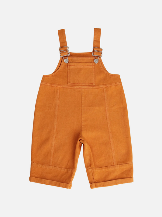 Image of The BLYTHE MARMALADE DUNGAREE is a slouchy, unisex overall in orange organic cotton twill with adjustable buckle straps and rolled cuffs, shown flat on a white background.