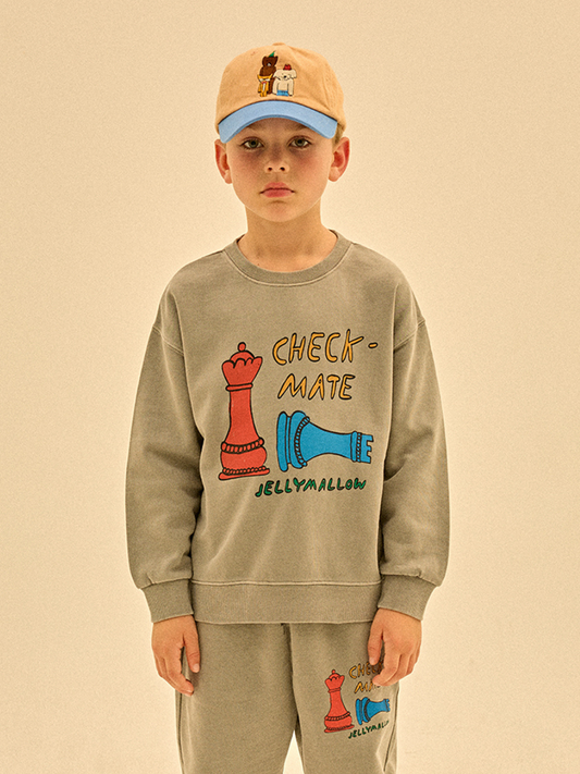 Second image of The CHECKMATE PIGMENT SWEATSHIRT is a grey sweatshirt with a graphic of a red chess queen, a toppled blue king, and the words "CHECK-MATE," "JELLYMALLOW," plus playful cost and tariff references on the front.