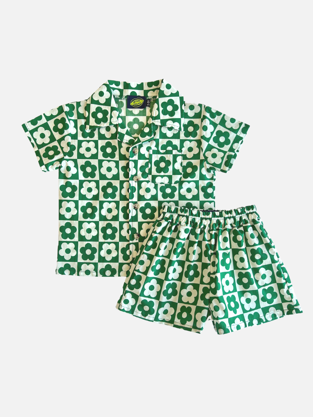 Set of kids' shirt and shorts printed in a checkerboard pattern with green flowers on a white background and white flowers on a green background, front view