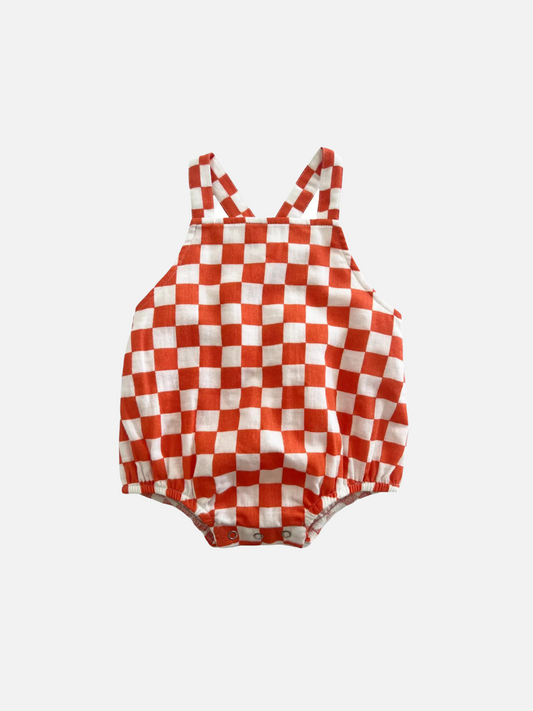 Image of A tangerine orange and white checkerboard kids' sunsuit, front view