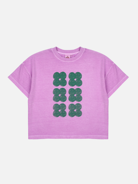 Image of Purple | Front of T-shirt with six dark green clover shapes in two vertical rows on a light purple background.