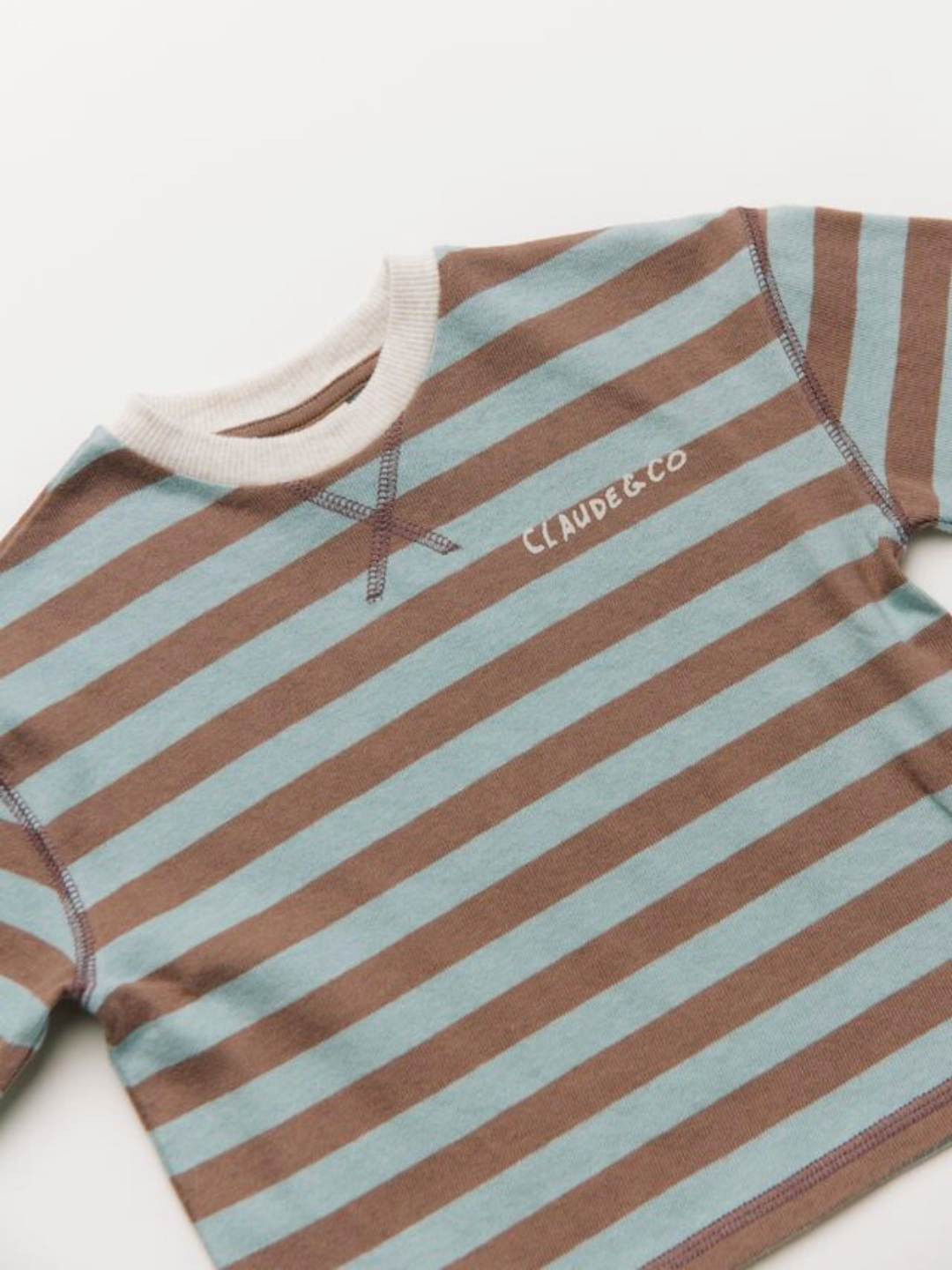 The RUE CHOC STRIPE LONG SLEEVE TEE features brown and light blue stripes, a white ribbed collar, long sleeves, and "CLAUDE & CO" printed on the chest.