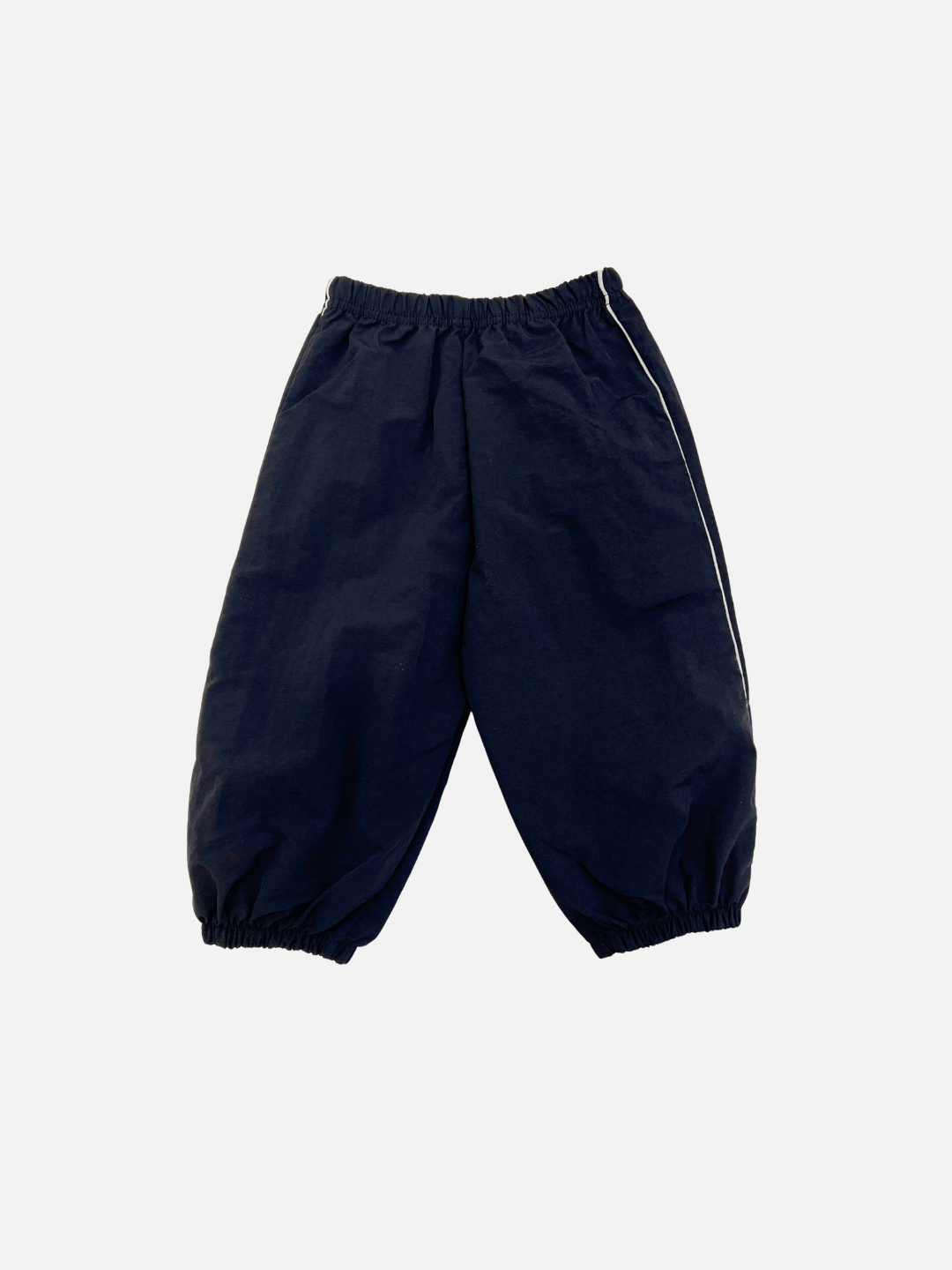 Black | MINI WARMUP PANTS in dark navy blue, featuring an elastic waistband and cuffs, displayed flat on a plain white background.