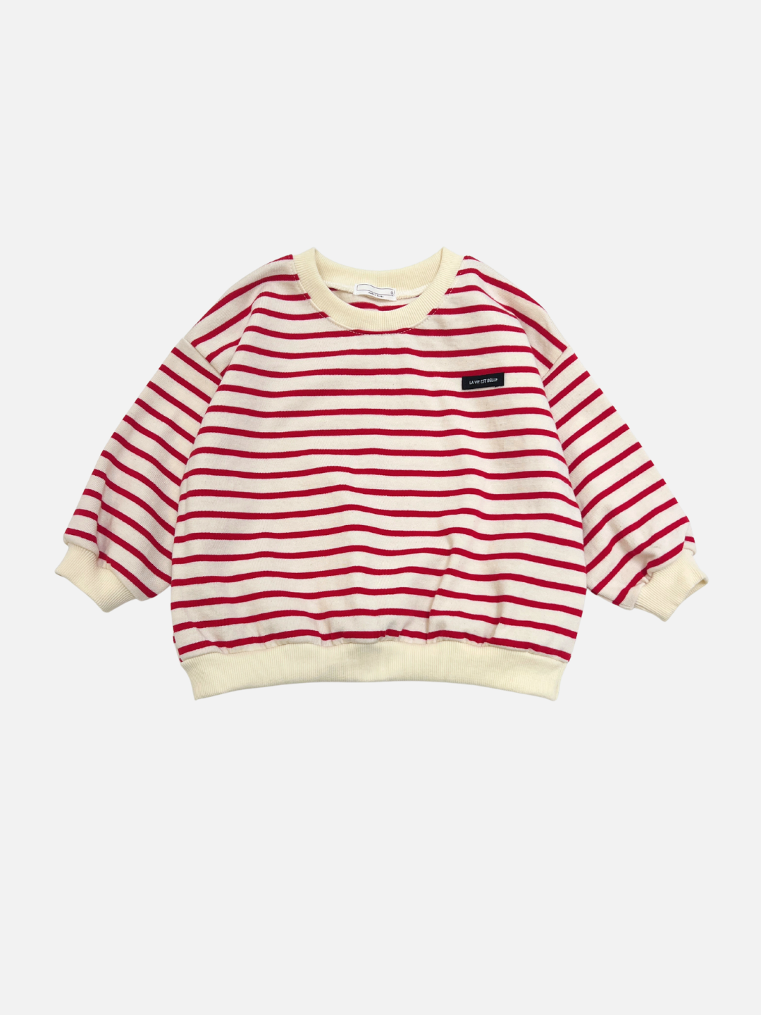 The BRETON BABY SWEATSHIRT is a children's long-sleeve shirt in red with classic stripes, cream cuffs and collar, and a trendy black chest patch.