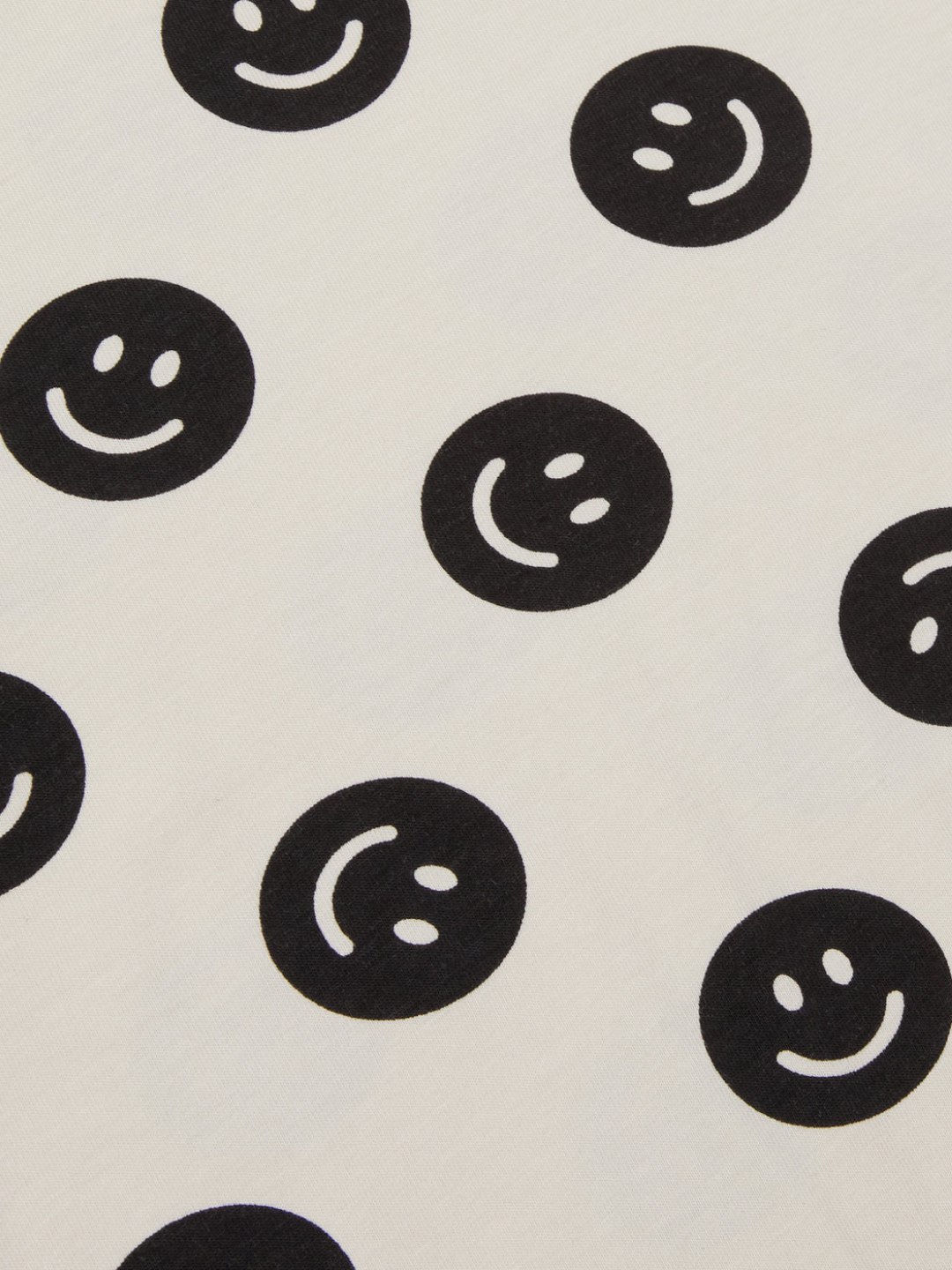 A zoomed in picture of the black smiley face pattern on the cream background.