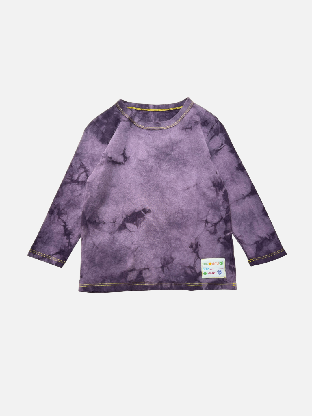 The COSMO TIE DYE LONG SLEEVE in Grape features yellow stitching and a white patch label near the hem, shown on a white background. Designed in Los Angeles for standout style.