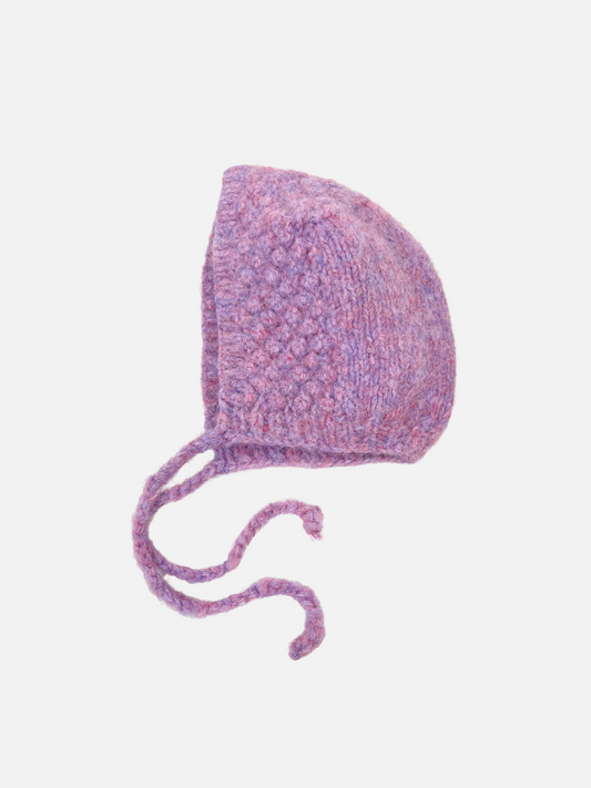 Image of The POPCORN BONNET is a cozy purple knit bonnet with ear flaps and two long ties, featuring a felted texture against a white background.