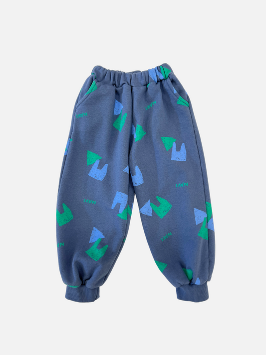 Image of Vintage Blue | Front view of kids blue sweatpants with an all over pattern of green and blue shapes and the brand name Navi.