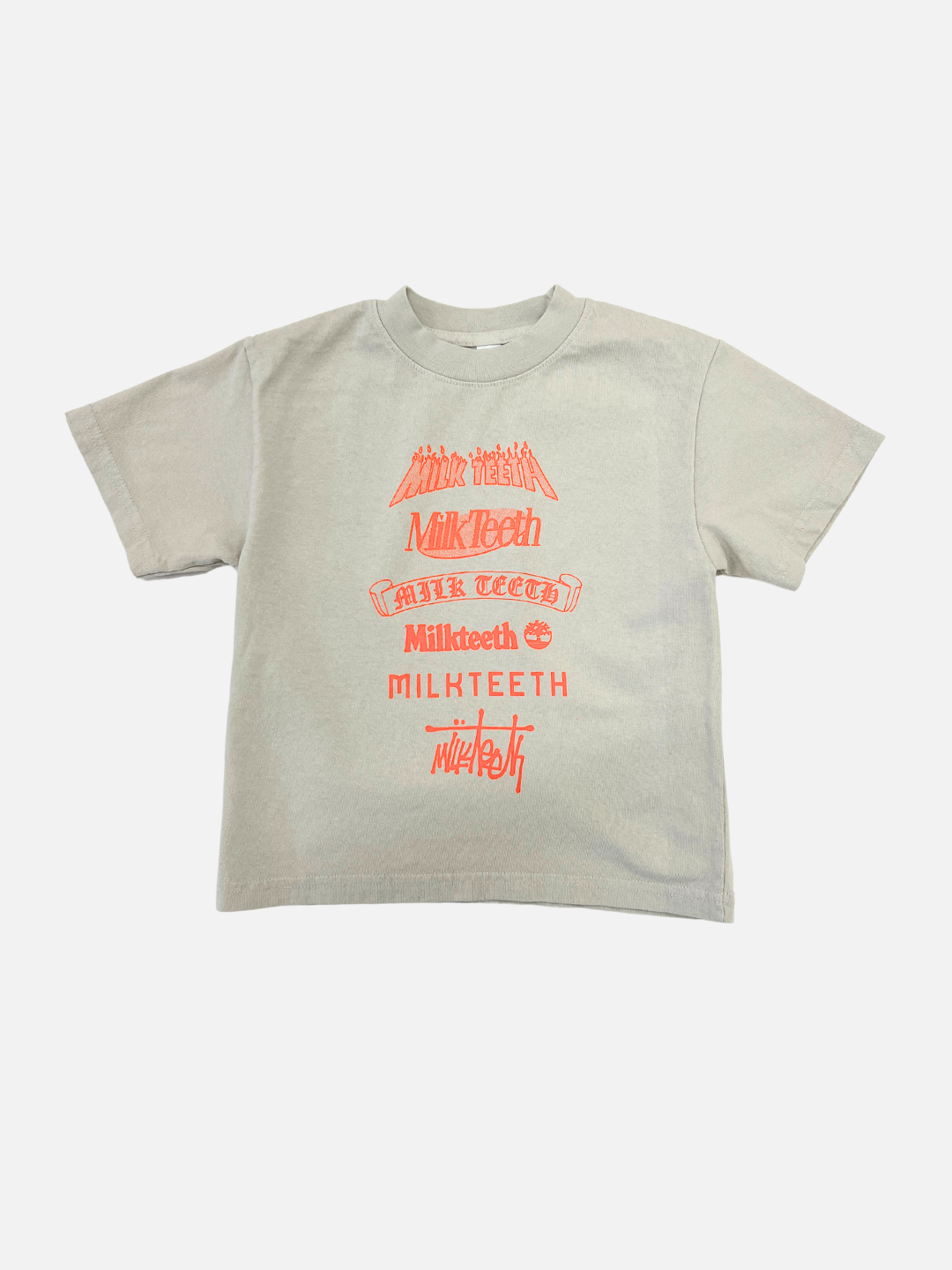 Cement | Front view of kids short sleeved t-shirt on cement grey with neon orange text spelling Milk Teeth in various fonts.