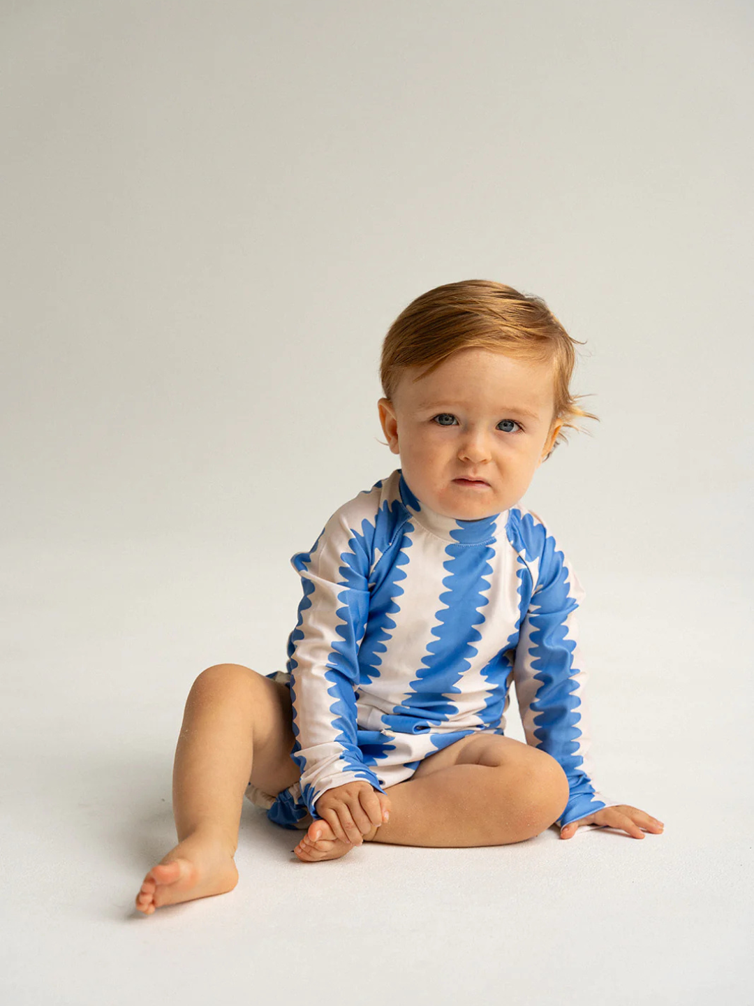 Blueberry | A child is wearing a rash guard with the matching swim nappy