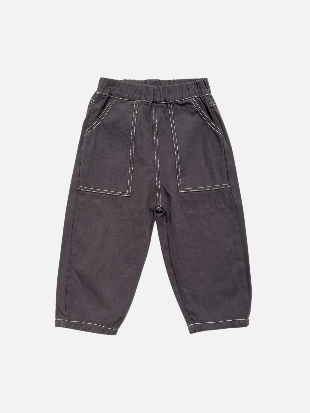 Charcoal | Kids baggy dark grey pants with contrast white topstitching on large patch pockets, shown flat on a light grey background.