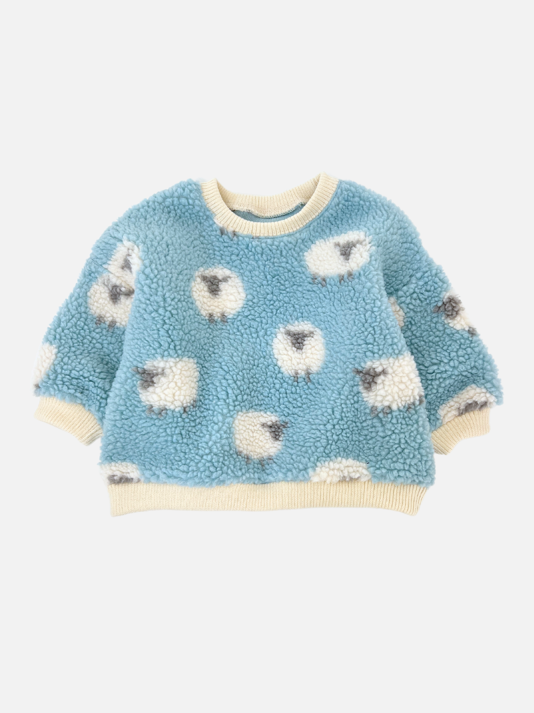 The SHEEP BABY SWEATSHIRT from a renowned Korean baby brand is a cozy, fuzzy blue garment that showcases an adorable pattern of fluffy sheep and is accented with cream-colored cuffs and collar against a plain background.