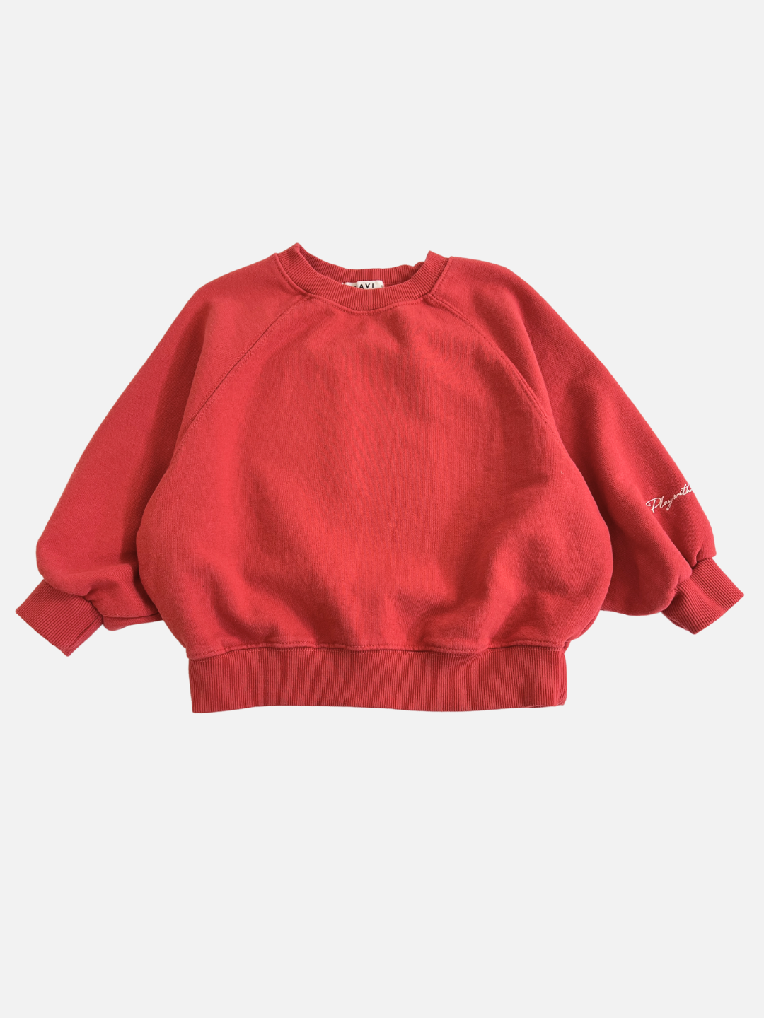 Red | The PLAYDATE SWEATSHIRT, a red oversized garment-dyed cotton terry design from a Korean kids brand, features long sleeves and ribbed cuffs. It’s ideal for those seeking stylish quality, shown here flat against a white background.