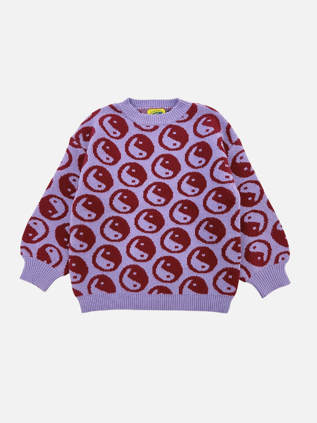 Violet | The COSMOS SWEATER is a super-soft purple crewneck featuring a red and light purple smiling face pattern throughout the intarsia knit fabric. It also includes a round neckline and ribbed cuffs and hem.