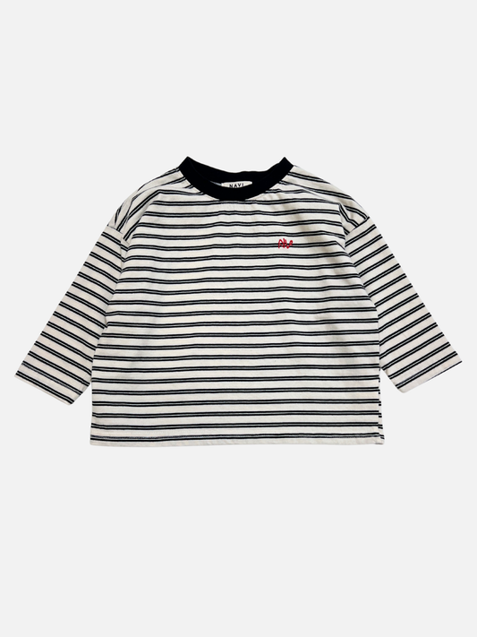Image of White | The CANOE LONGSLEEVE TEE in white features black and white stripes, a black collar, and a small red embroidered design on the left chest.