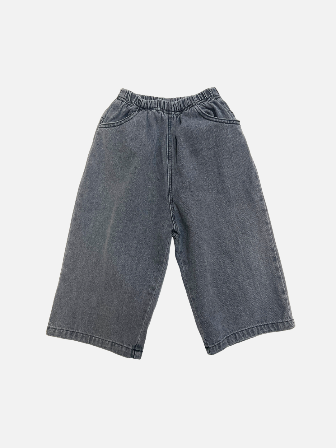 The PEPPER JEAN in Grey features wide legs, a cropped fit, an elastic waistband, and side pockets, displayed on a plain white background.