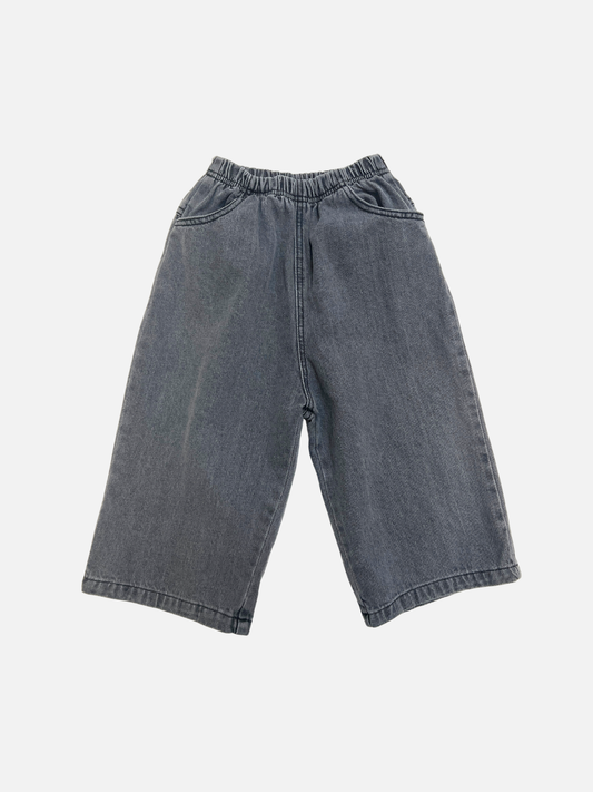 Image of Grey | The PEPPER JEAN in Grey features wide legs, a cropped fit, an elastic waistband, and side pockets, displayed on a plain white background.