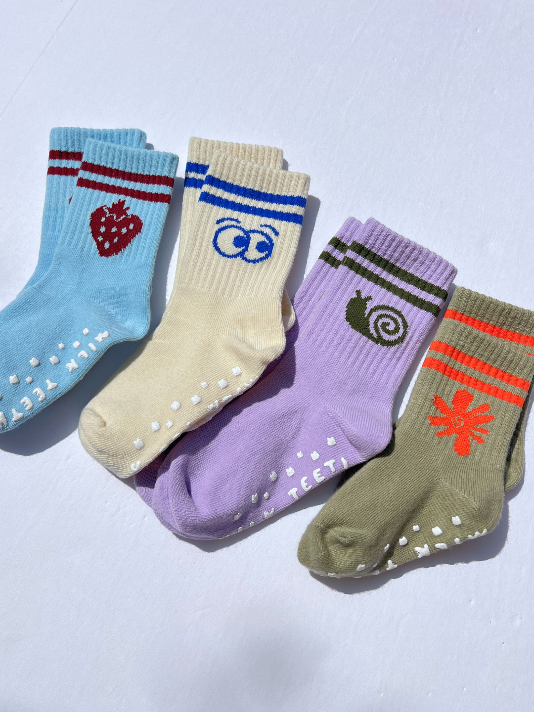 Five colorful socks with various designs on a light gray background