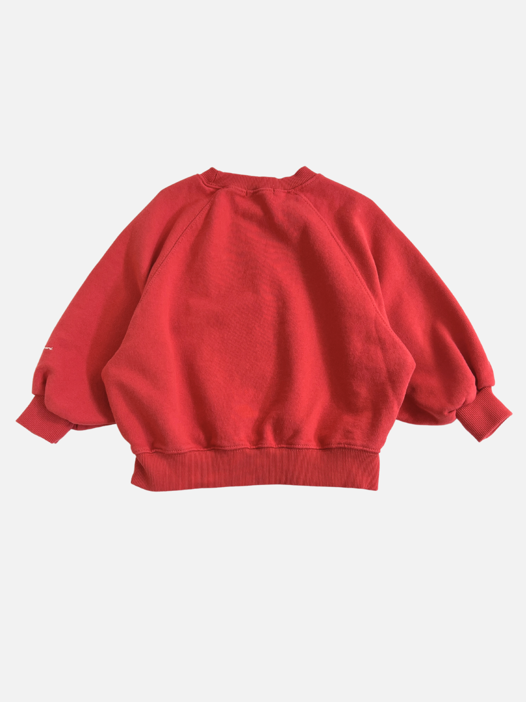 Red | The PLAYDATE SWEATSHIRT in red, made from garment-dyed cotton terry with drop shoulders and ribbed cuffs, is showcased flat on a white background.