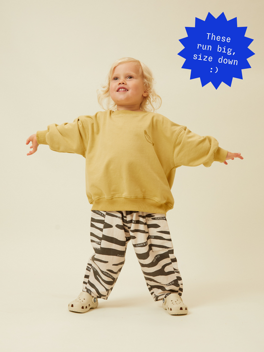 Second image of The EMERSON ZEBRA TROUSER features a black and white zebra pattern with an oversized silhouette, "Claude & Co" text print, and is crafted from organic cotton. It offers an elastic waistband and side pockets for comfort and style.