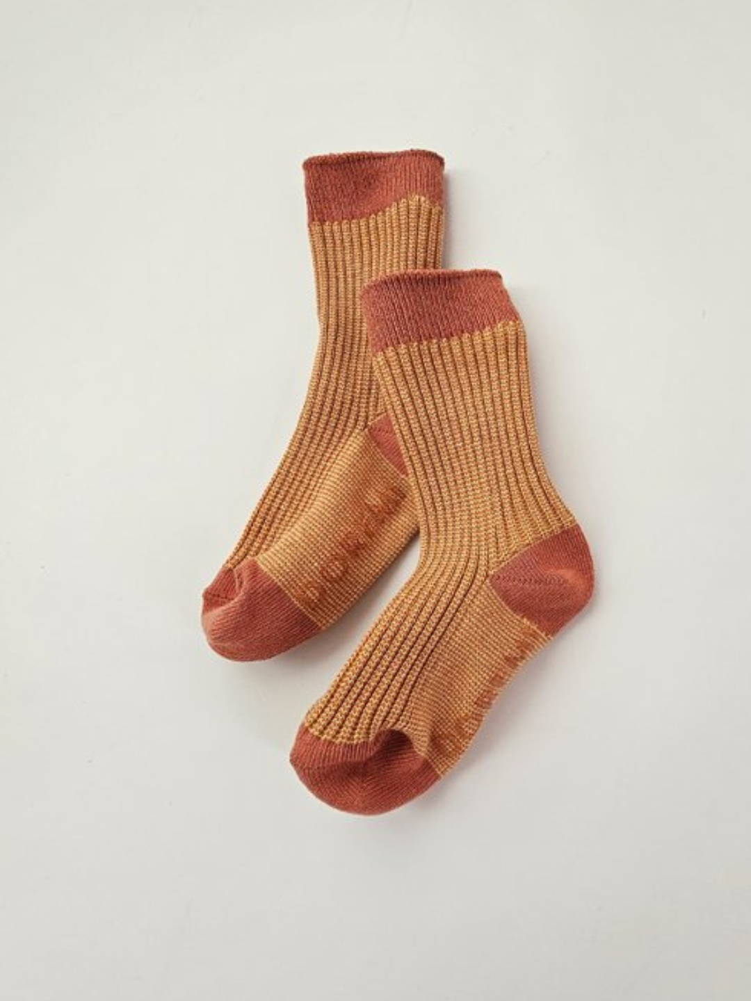 A vibrant pair of orange and brown, ribbed socks from the TRIO SOCK SET collection displayed on a white background.