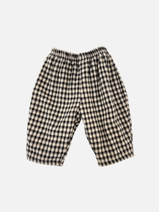 Image of FLEECE-LINED BABY PANT in a black and white checkered design, featuring an elastic waistband and a cozy polar fleece lining, displayed on a plain white background.