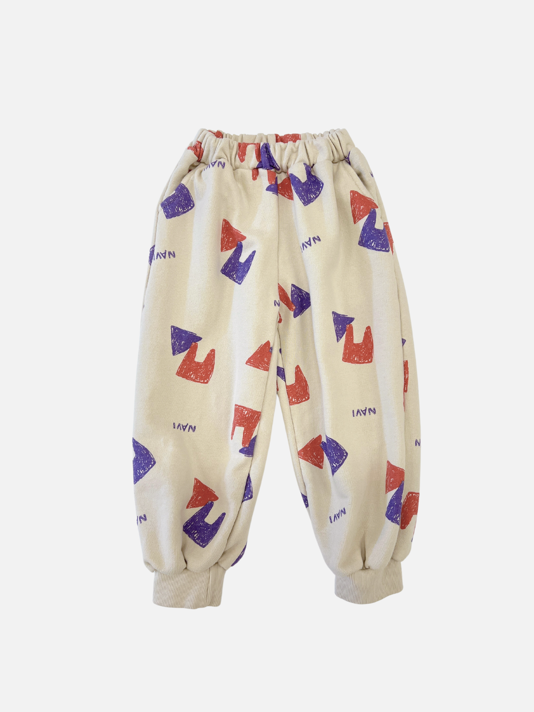 Front view of kids beige sweatpants with an all over pattern of red and purple shapes and the brand name Navi.