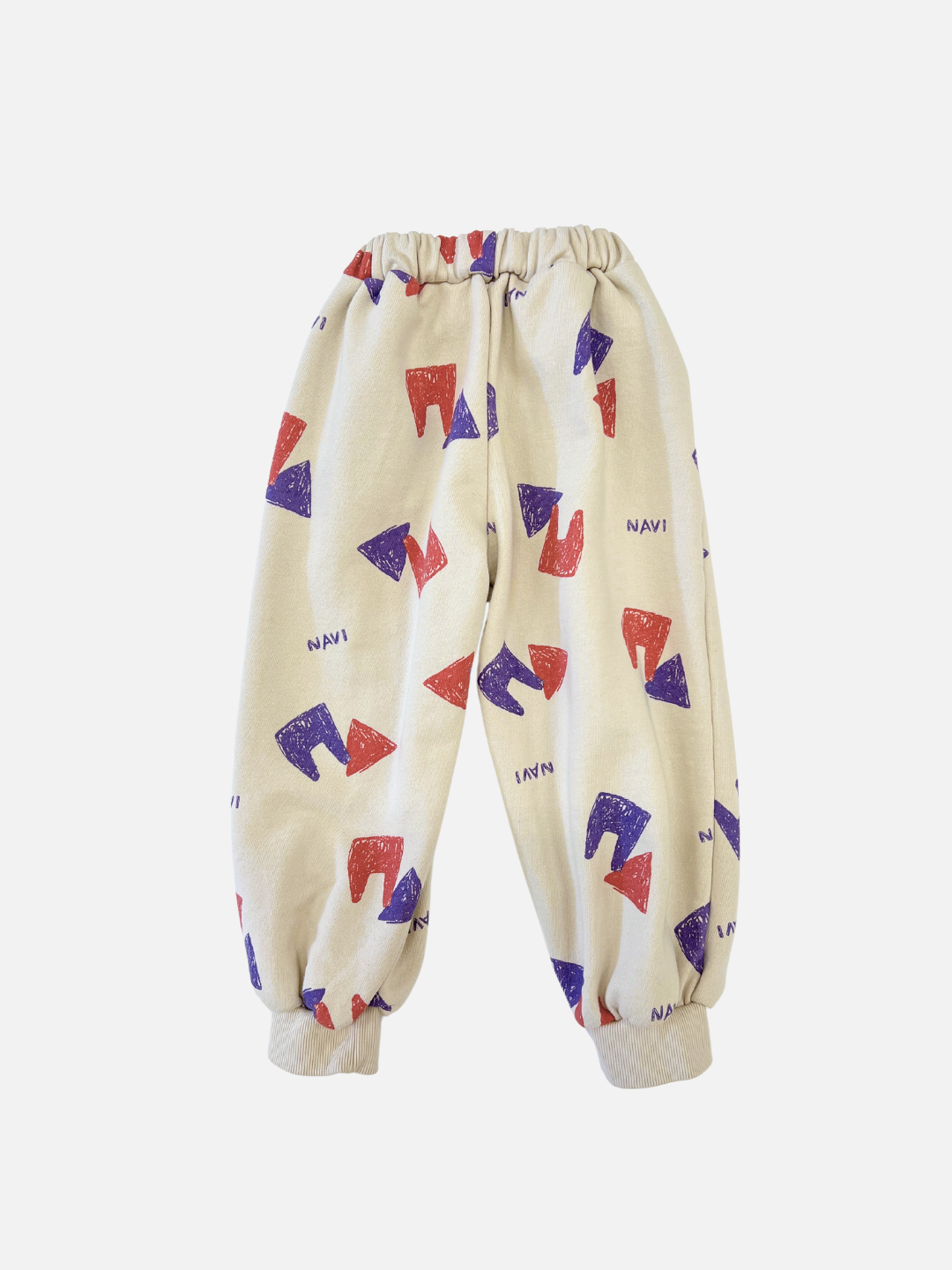 Back view of kids beige sweatpants with an all over pattern of red and purple shapes and the brand name Navi.