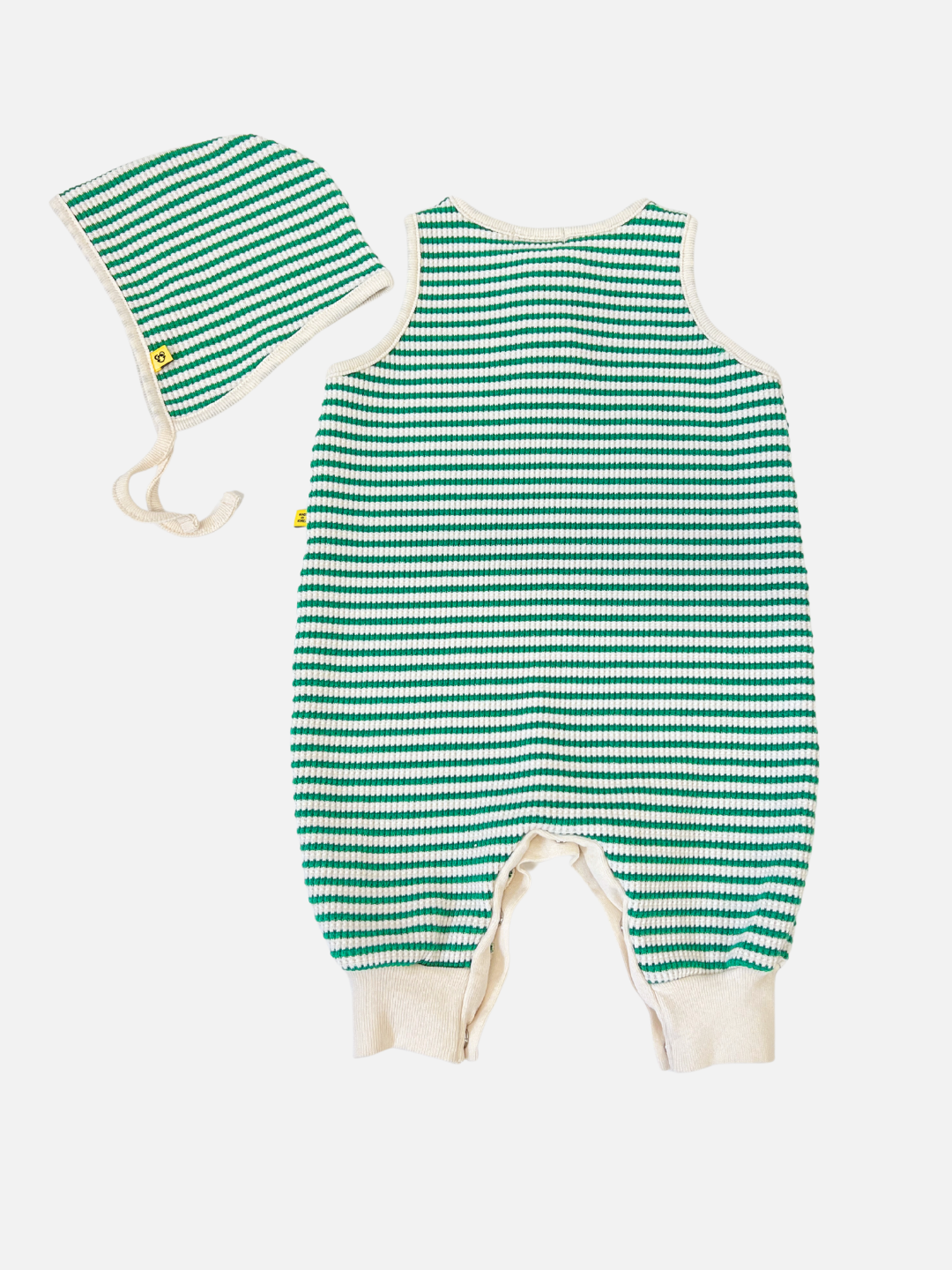 Green | The STRIPE WAFFLE ROMPER SET includes a green and white striped baby romper made from soft waffle cotton, accompanied by a matching bonnet. Both have a small yellow tag on a crisp white background.