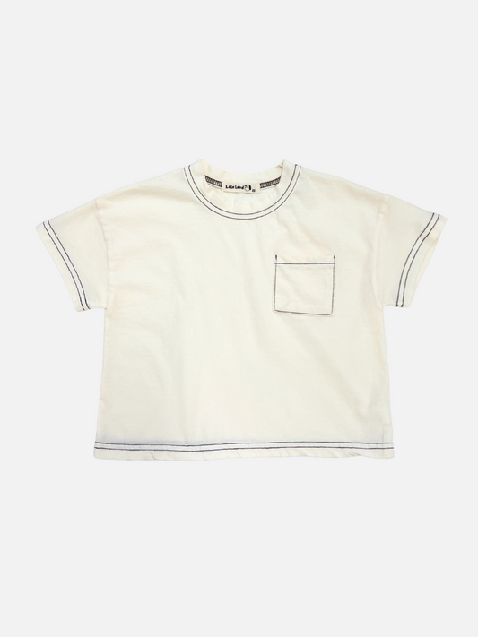 Image of Ivory | Front view of the kids' stitch pocket tee in Ivory feturing contrast black stitch and a small pocket on the right side