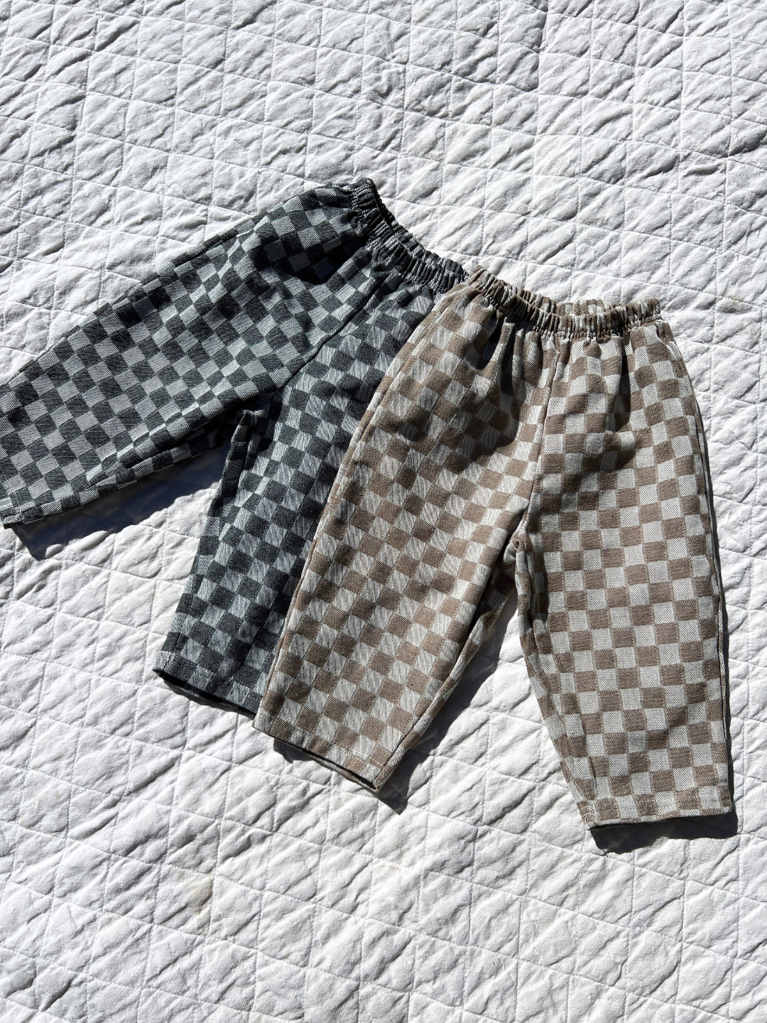 Stone & Charcoal Chess Club Pants laid on blanket