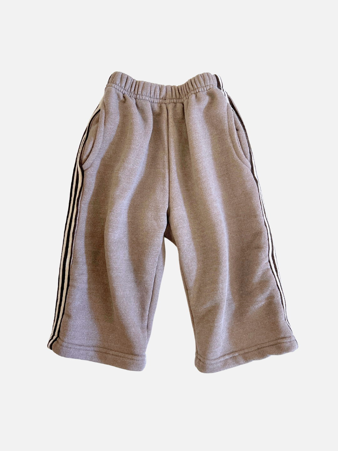 The ALL DAY PANT features a relaxed fit with gray fabric, black side stripes, an elastic waistband, and two front pockets. Crafted from soft brushed cotton fleece on a plain white background.