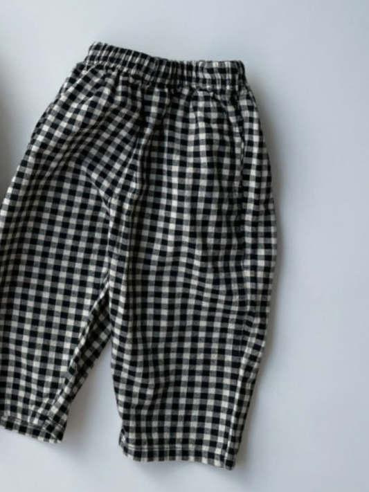 Second image of Front view of kids black and off-white gingham check pants.