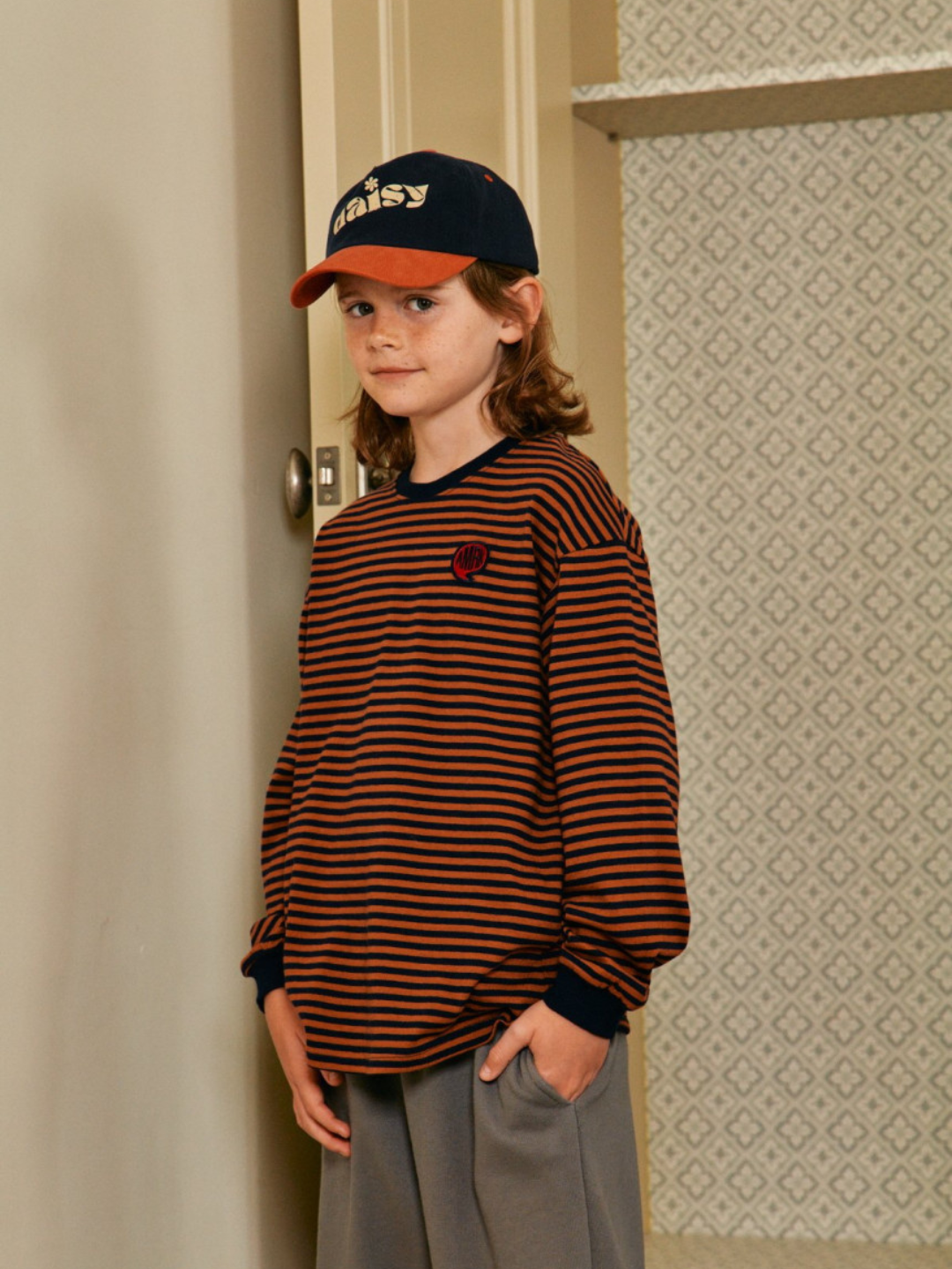 Rust/Navy | Child is wearing Comma Striped Longsleeve in Rust/Navy
