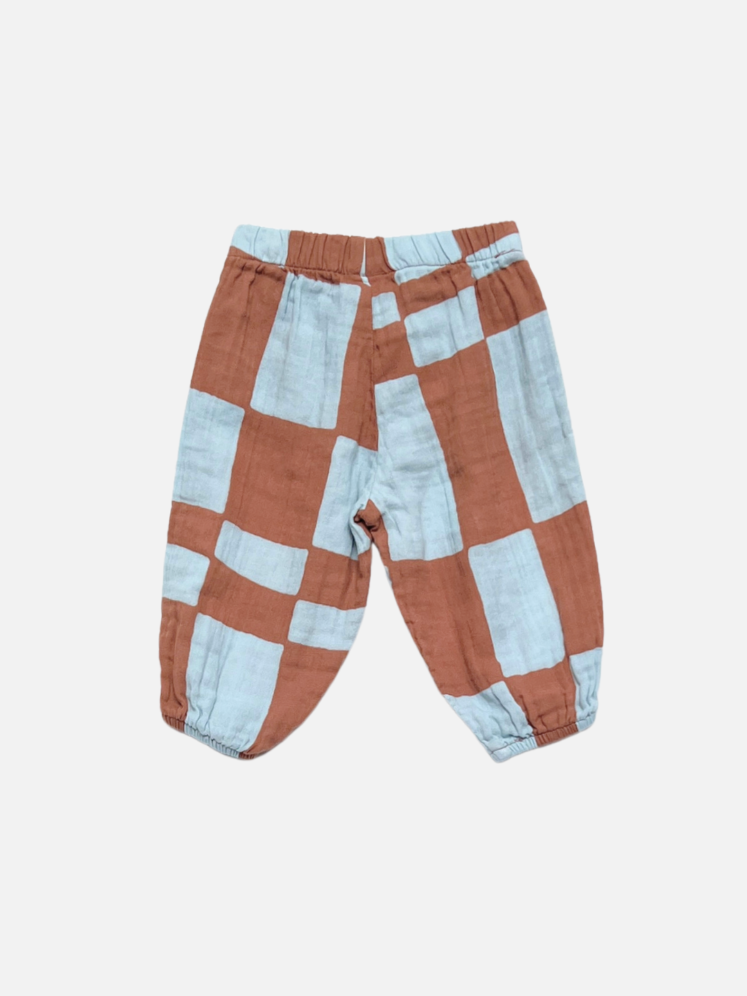The MUSLIN PULL ON PANT is a toddler jogger with an elastic waistband and cuffs, showcasing a large brown and light blue checkered print on a white background.